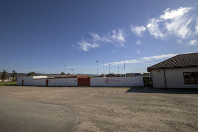 Houses by buildings against blue sky