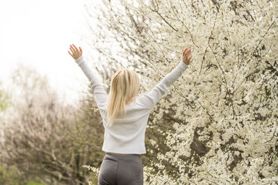 Portrait of a young woman in a blooming orchard. blonde woman