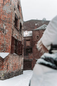 Midsection of person against building during winter