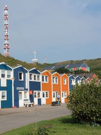 Houses by buildings in town against sky