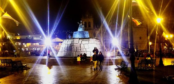 Group of people in illuminated city at night