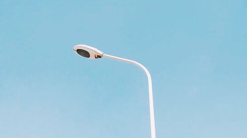 Low angle view of street light against blue sky