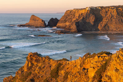 Scenic view of rocks on beach against sky