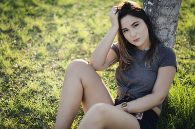 Portrait of young woman sitting on field