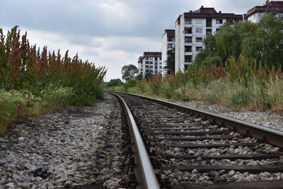 Railroad track amidst buildings against sky
