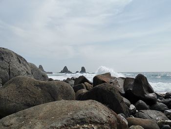 Rocks by sea against sky