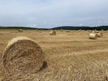 Hay bales on field against sky