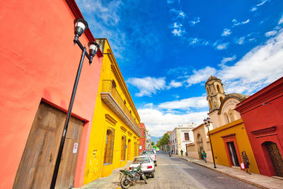 Low angle view of street amidst buildings against sky