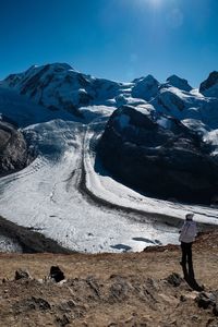 Rear view of man standing on snow covered landscape