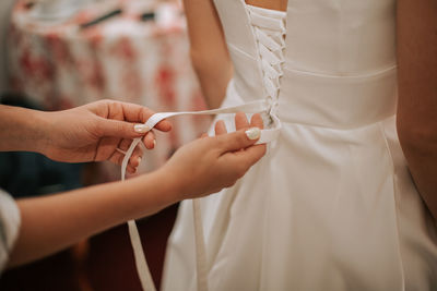 Midsection of bride getting dressed