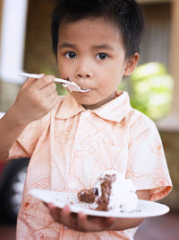 Close-up portrait of boy eating birthday cake