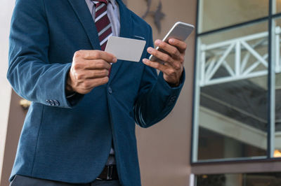 Midsection of woman using mobile phone