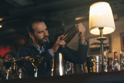 Male bartender preparing cocktail at bar counter