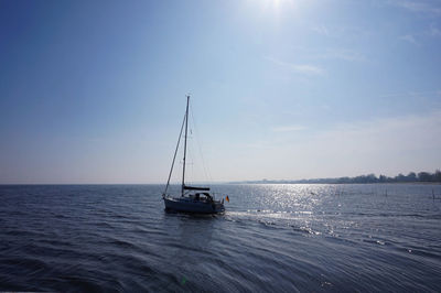 Sailboat sailing on sea against sky