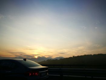 Car on road against sky during sunset