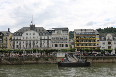 Boats in river against buildings in city