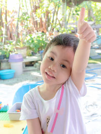 3 years old cute baby asian girl, little toddler child with adorable short hair showing thumbs up.