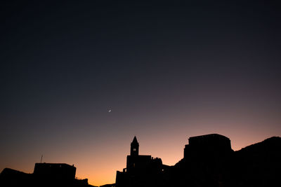 Low angle view of silhouette buildings against sky at sunset