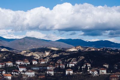 Town by mountains against sky