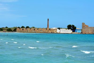 View of sea and buildings against clear sky