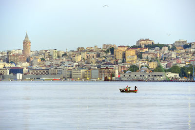 Boat in sea against buildings in city