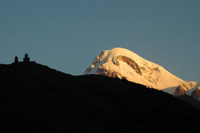 Low angle view of snowcapped mountains against clear sky