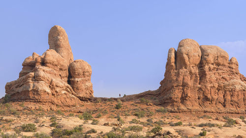 Hiker against blue sky at turret arch in arches national park