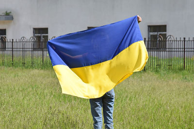 Low section of woman holding american flag on field