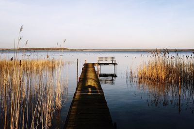 Pier on river against sky