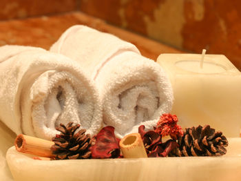 Close-up of pine cones with rolled towels and candle