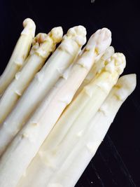 Close-up of white asparaguses against black background