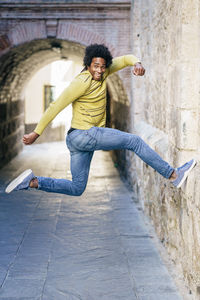 Portrait of young man jumping outdoors