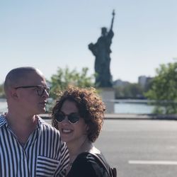 Couple standing against statue of liberty