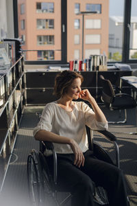 Disabled business woman sitting in wheelchair, smiling