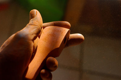 Close-up of hand holding wet leaf