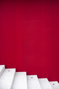 White ladder on red wall background