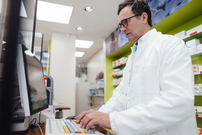 Pharmacist using desktop pc in store