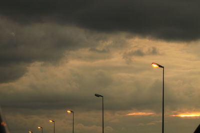 Low angle view of illuminated street light against sky at sunset