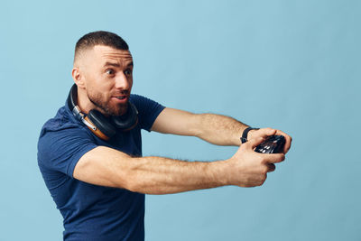 Low angle view of man exercising against blue background