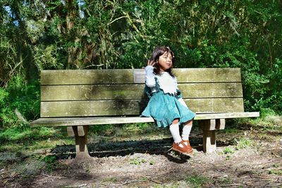 Girl sitting on bench in park