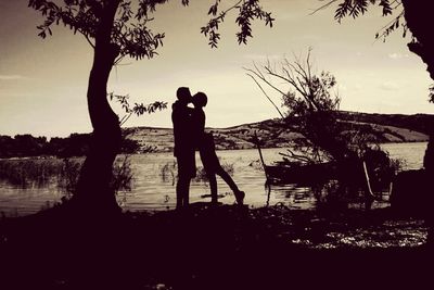 Silhouette of woman in water at sunset