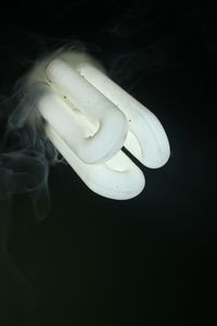 Close-up of illuminated light bulb against black background