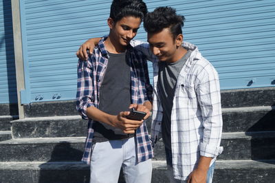 Side view of young man using mobile phone