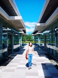 Full length portrait of woman on footpath