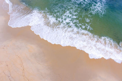 High angle view of waves rushing towards shore