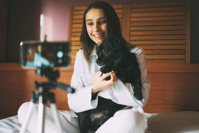 Veterinary surgeon filming a video with a dog. online veterinary.