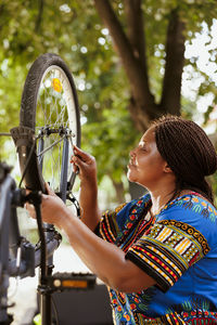 Side view of young woman with bicycle