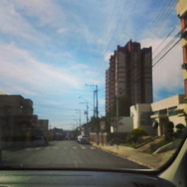 transportation, building exterior, car, road, architecture, built structure, sky, street, land vehicle, city, mode of transport, the way forward, road marking, windshield, diminishing perspective, transparent, glass - material, no people, on the move, day