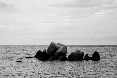 Rocks on sea shore against sky