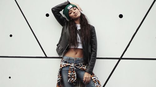 Young woman looking away against sky